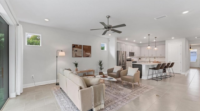 living area featuring recessed lighting, a ceiling fan, visible vents, and baseboards