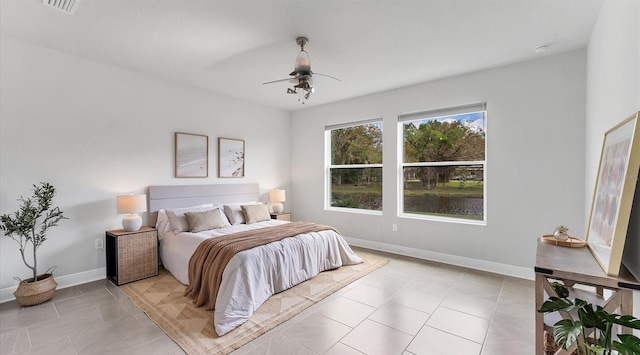 bedroom featuring light tile patterned floors, visible vents, baseboards, and a ceiling fan