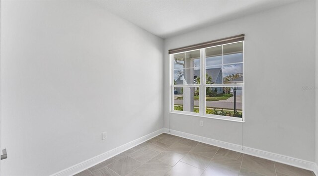 spare room with baseboards