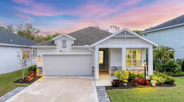 view of front of property with a front lawn, an attached garage, stone siding, and driveway