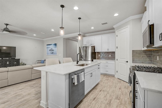 kitchen with light wood finished floors, visible vents, open floor plan, appliances with stainless steel finishes, and a sink