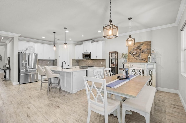 dining space with recessed lighting, baseboards, light wood finished floors, and ornamental molding