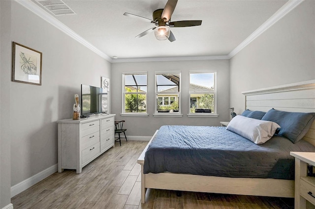 bedroom with baseboards, visible vents, light wood-type flooring, and ornamental molding