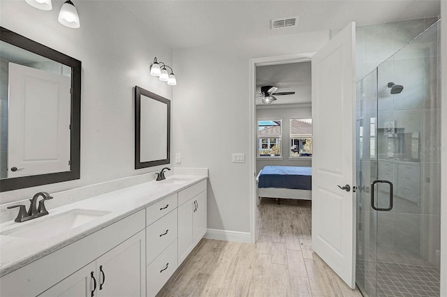 ensuite bathroom featuring visible vents, a stall shower, and a sink