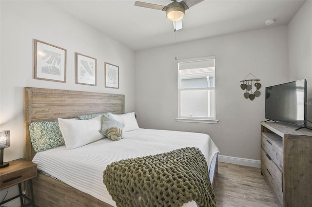 bedroom featuring baseboards, wood finished floors, and a ceiling fan