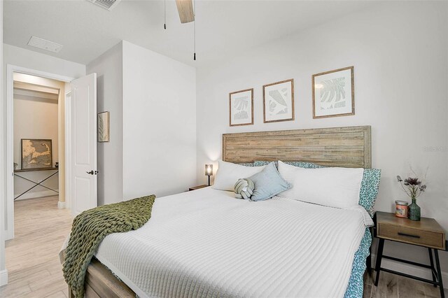 bedroom featuring wood finished floors, visible vents, and ceiling fan