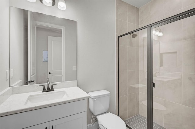 bathroom featuring vanity, a shower stall, and toilet