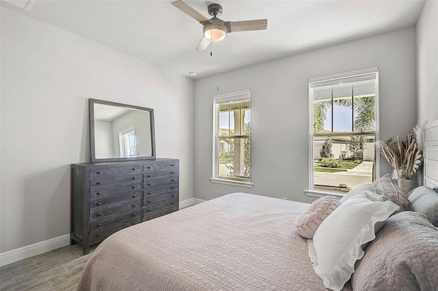 bedroom with baseboards, a ceiling fan, and wood tiled floor