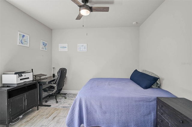 bedroom with baseboards, light wood-style flooring, and a ceiling fan