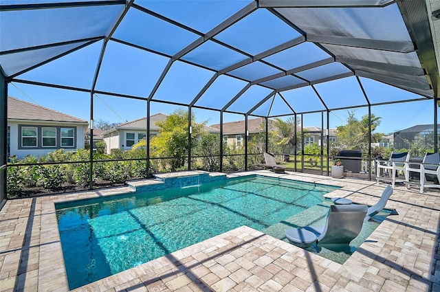 pool featuring glass enclosure and a patio