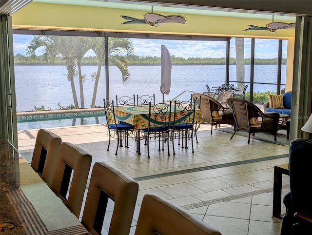 dining room featuring a water view and tile patterned flooring