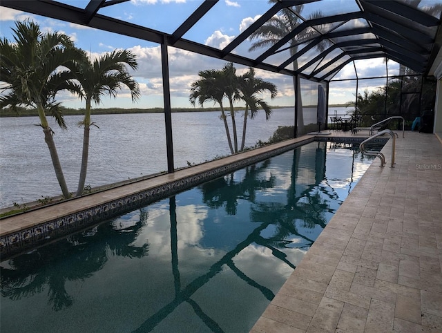 outdoor pool featuring a water view, a lanai, and a patio