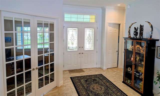 foyer with baseboards, ornamental molding, and french doors