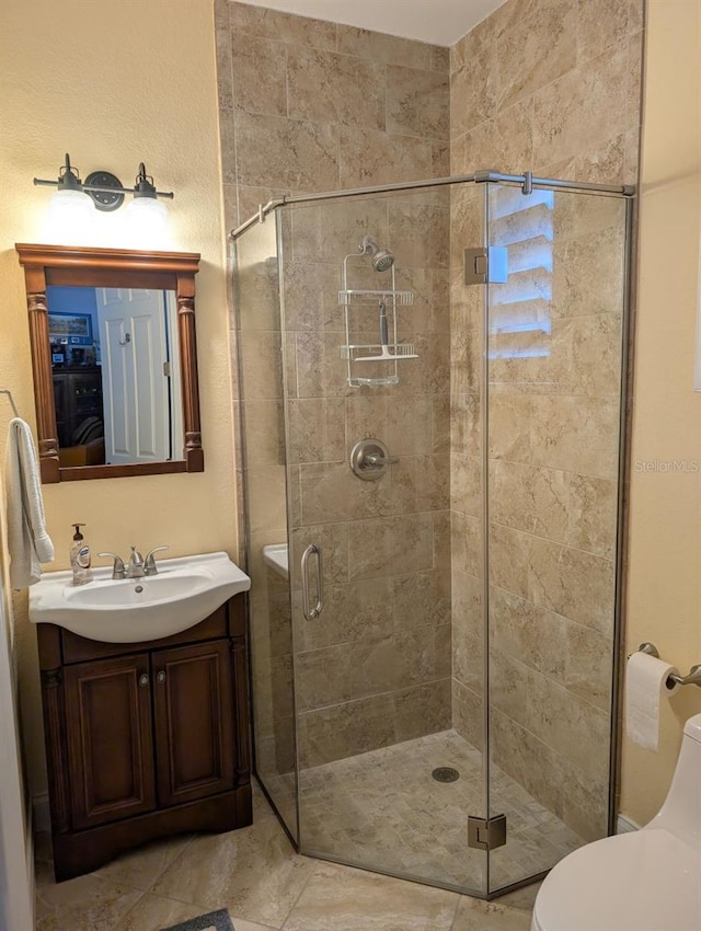 full bathroom featuring toilet, a stall shower, and vanity