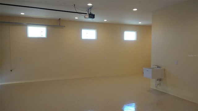 below grade area featuring a garage, plenty of natural light, a sink, and recessed lighting