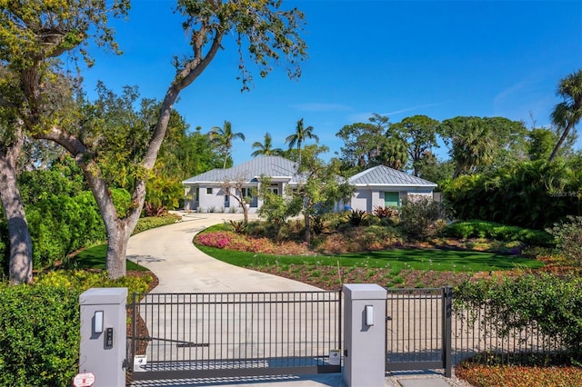 single story home featuring a fenced front yard, a gate, concrete driveway, and stucco siding