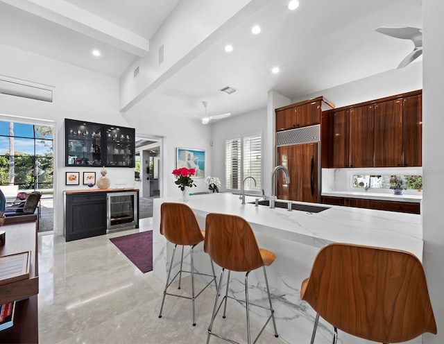 kitchen with beverage cooler, a ceiling fan, a sink, paneled built in refrigerator, and a wealth of natural light