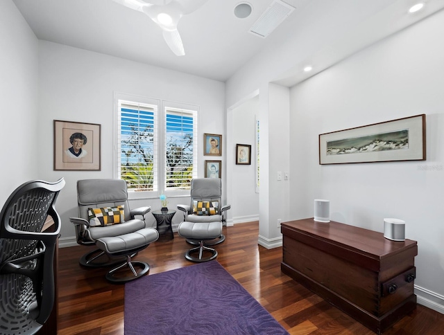 living area with visible vents, baseboards, and wood finished floors