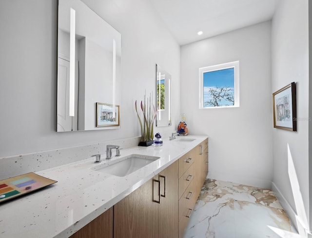 full bathroom featuring marble finish floor, double vanity, a sink, and recessed lighting