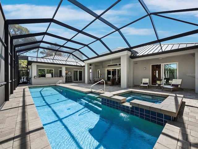 view of pool featuring a ceiling fan, a pool with connected hot tub, a patio, and a lanai