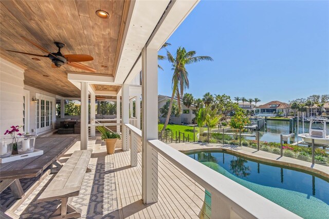 balcony featuring a residential view, french doors, a ceiling fan, and a water view