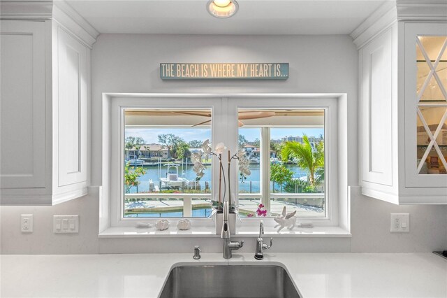 kitchen featuring white cabinetry, light countertops, and a water view