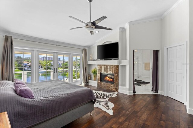 bedroom featuring a tiled fireplace, wood finished floors, french doors, crown molding, and vaulted ceiling