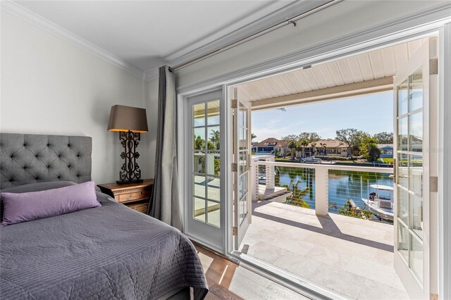 bedroom featuring access to outside, multiple windows, a water view, and ornamental molding