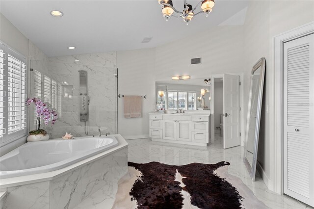 bathroom featuring a marble finish shower, a garden tub, a notable chandelier, marble finish floor, and vanity