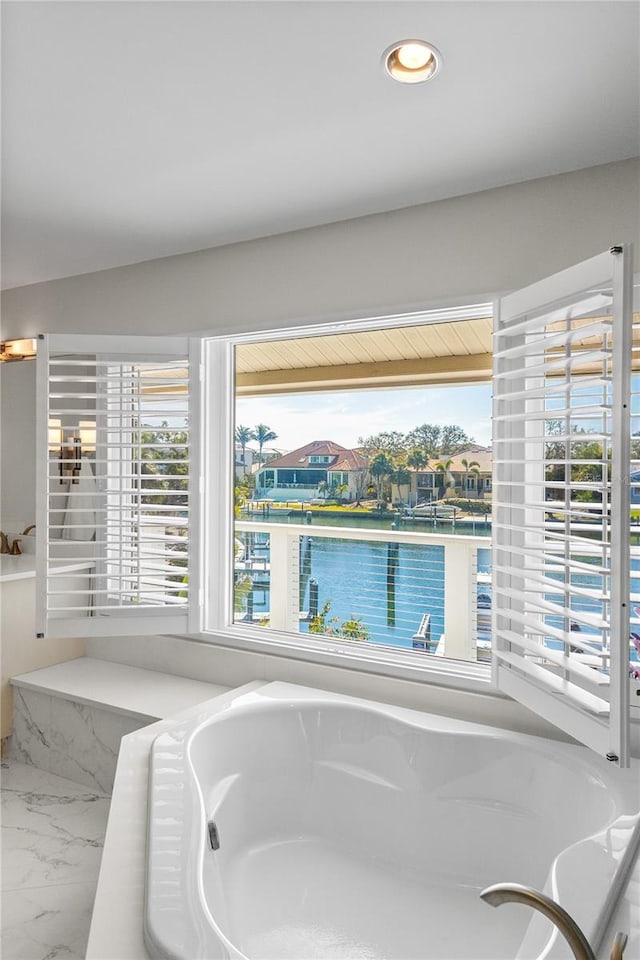 interior space featuring a bath, recessed lighting, and marble finish floor