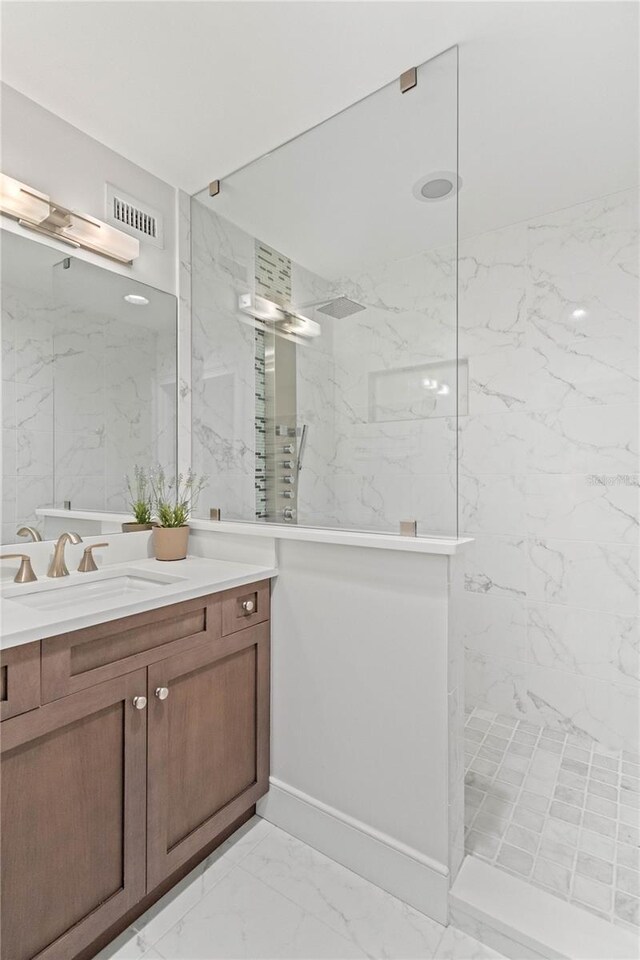 full bathroom featuring a marble finish shower, marble finish floor, vanity, and visible vents