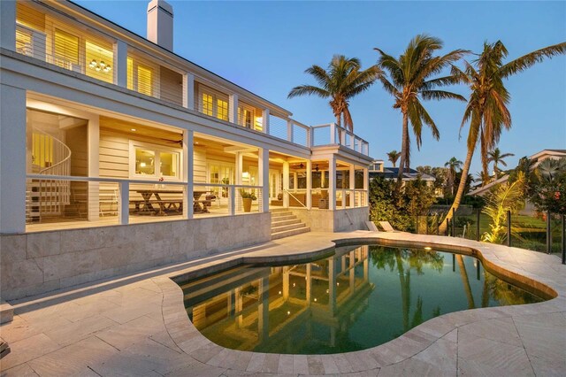 view of swimming pool featuring a fenced in pool, a ceiling fan, stairs, and a patio area