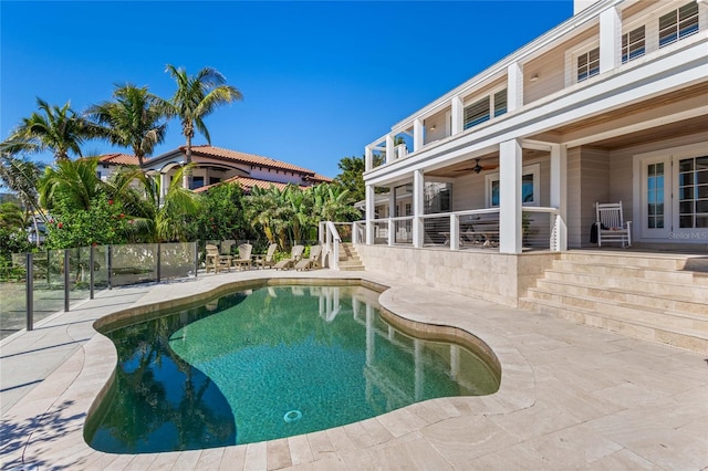 view of swimming pool featuring a patio, fence, a fenced in pool, and ceiling fan