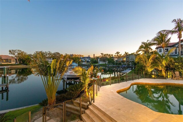 view of dock with a patio area, a water view, and boat lift