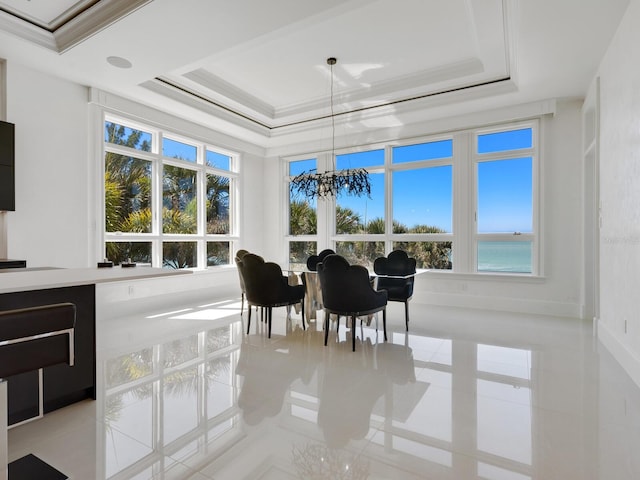 sunroom with a tray ceiling, a notable chandelier, and a healthy amount of sunlight