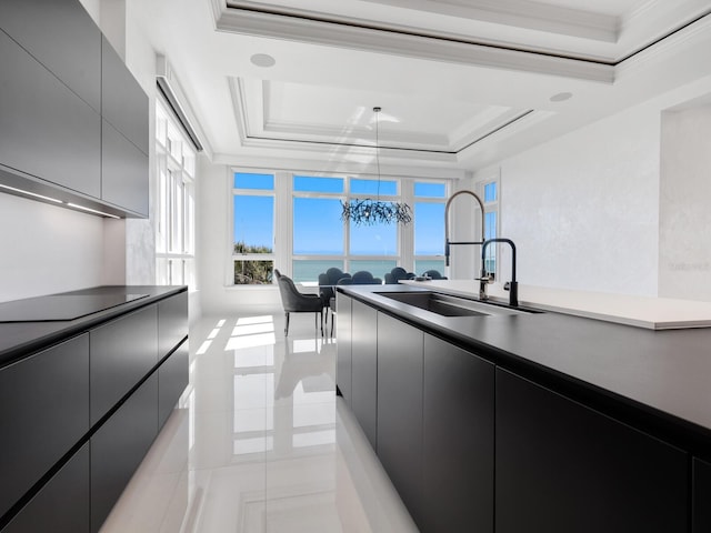 kitchen with modern cabinets, a sink, dark cabinetry, black electric cooktop, and a raised ceiling