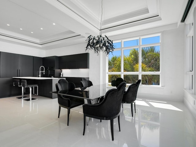 dining room with a raised ceiling, an inviting chandelier, and ornamental molding