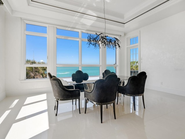 dining space with a tray ceiling, a healthy amount of sunlight, crown molding, and an inviting chandelier