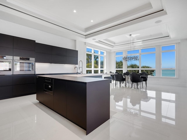 kitchen featuring oven, a raised ceiling, modern cabinets, and dark cabinetry