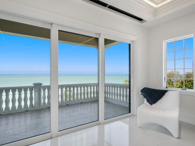 entryway featuring tile patterned flooring, crown molding, and a water view