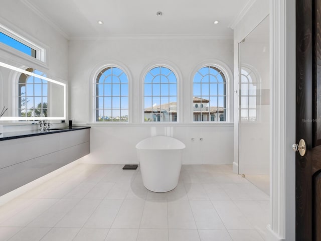 bathroom featuring tile patterned flooring, ornamental molding, plenty of natural light, and a freestanding bath