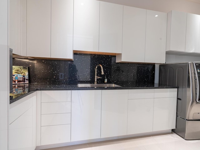 kitchen with a sink, washer / clothes dryer, modern cabinets, and white cabinets