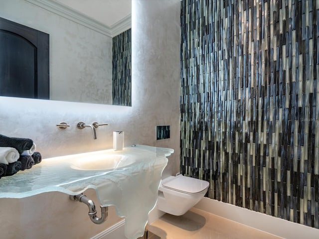 half bathroom with toilet and ornamental molding