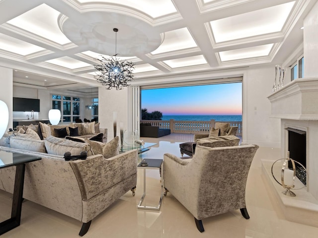 tiled living room with a high end fireplace, crown molding, a water view, a notable chandelier, and coffered ceiling