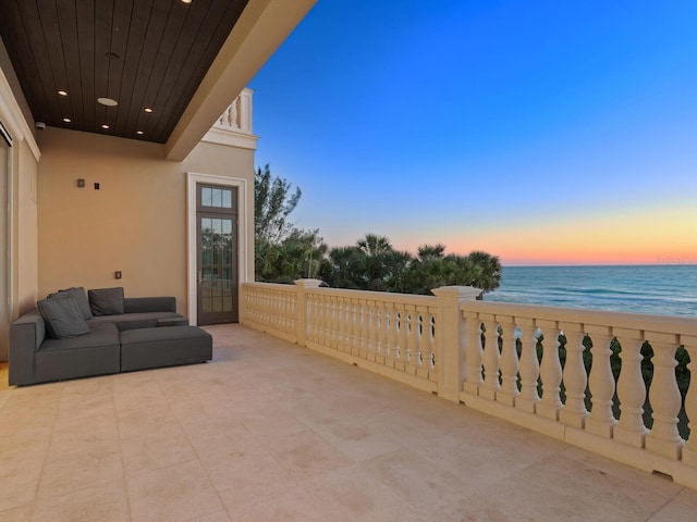 patio terrace at dusk featuring french doors and a water view