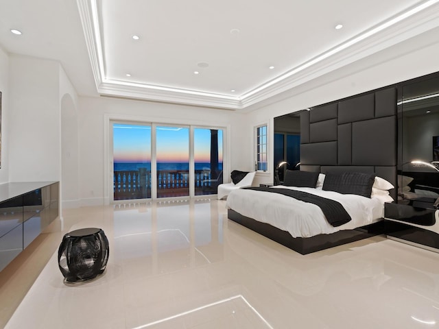 bedroom with a tray ceiling, recessed lighting, and arched walkways