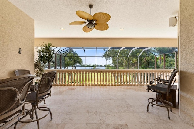 sunroom / solarium with a water view and ceiling fan