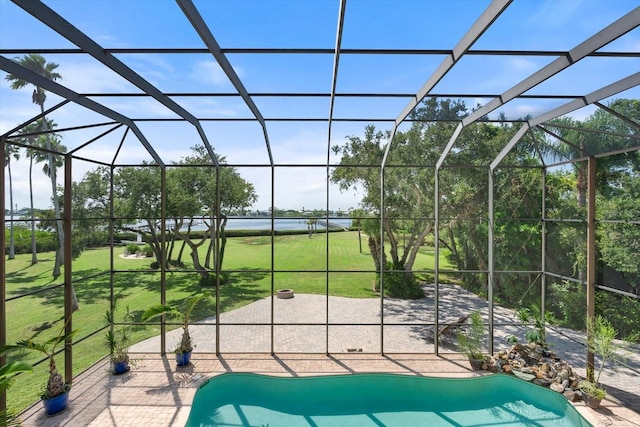 pool featuring a lanai, a patio, and a lawn