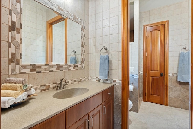 bathroom featuring toilet, tile patterned flooring, tile walls, and vanity