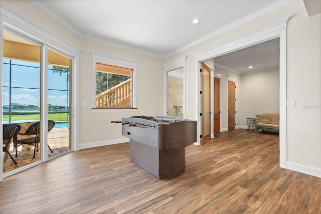 interior space with ornamental molding, baseboards, and wood finished floors